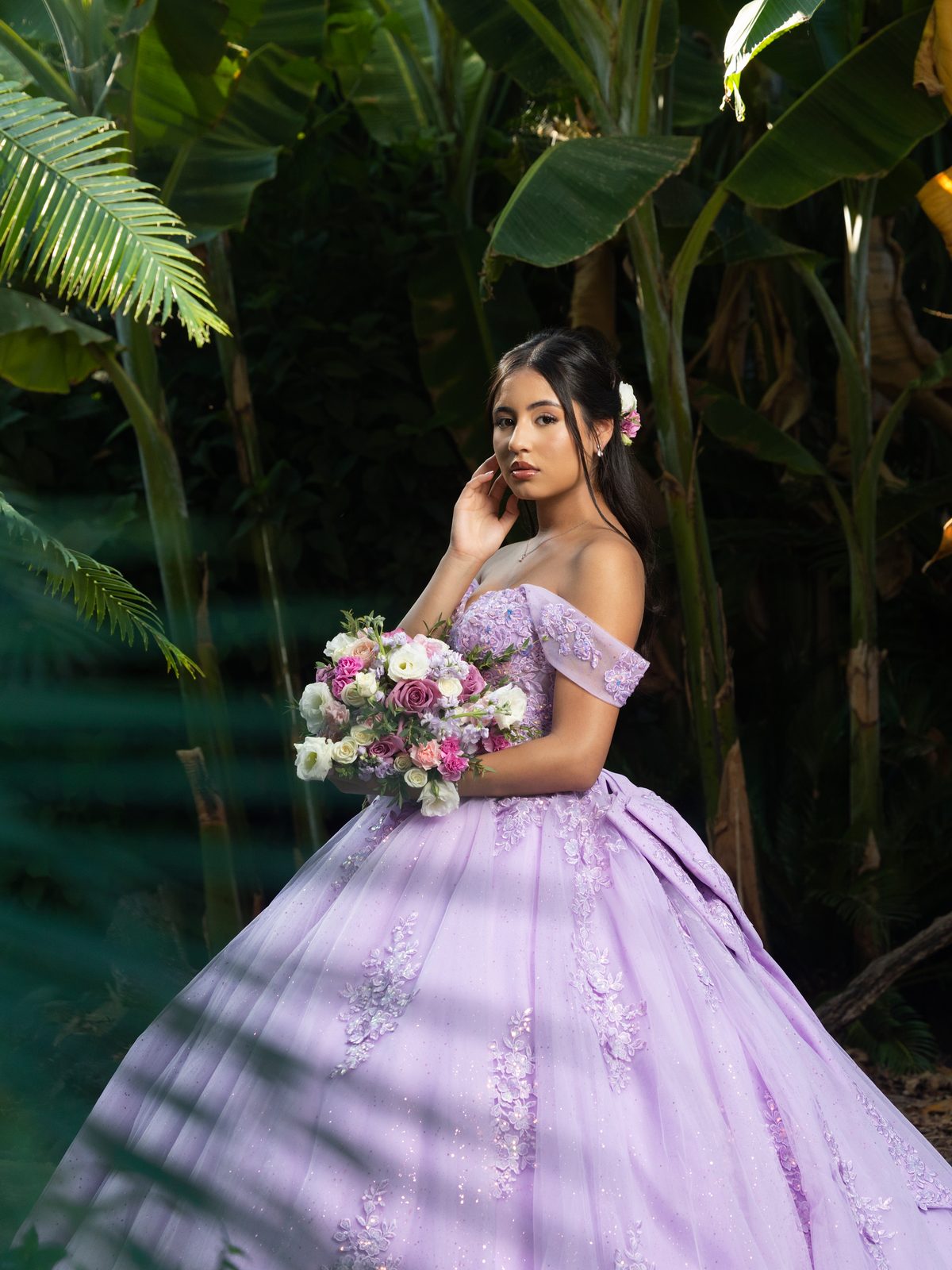 A lilac gown with a bouquet of roses among tropical leaves