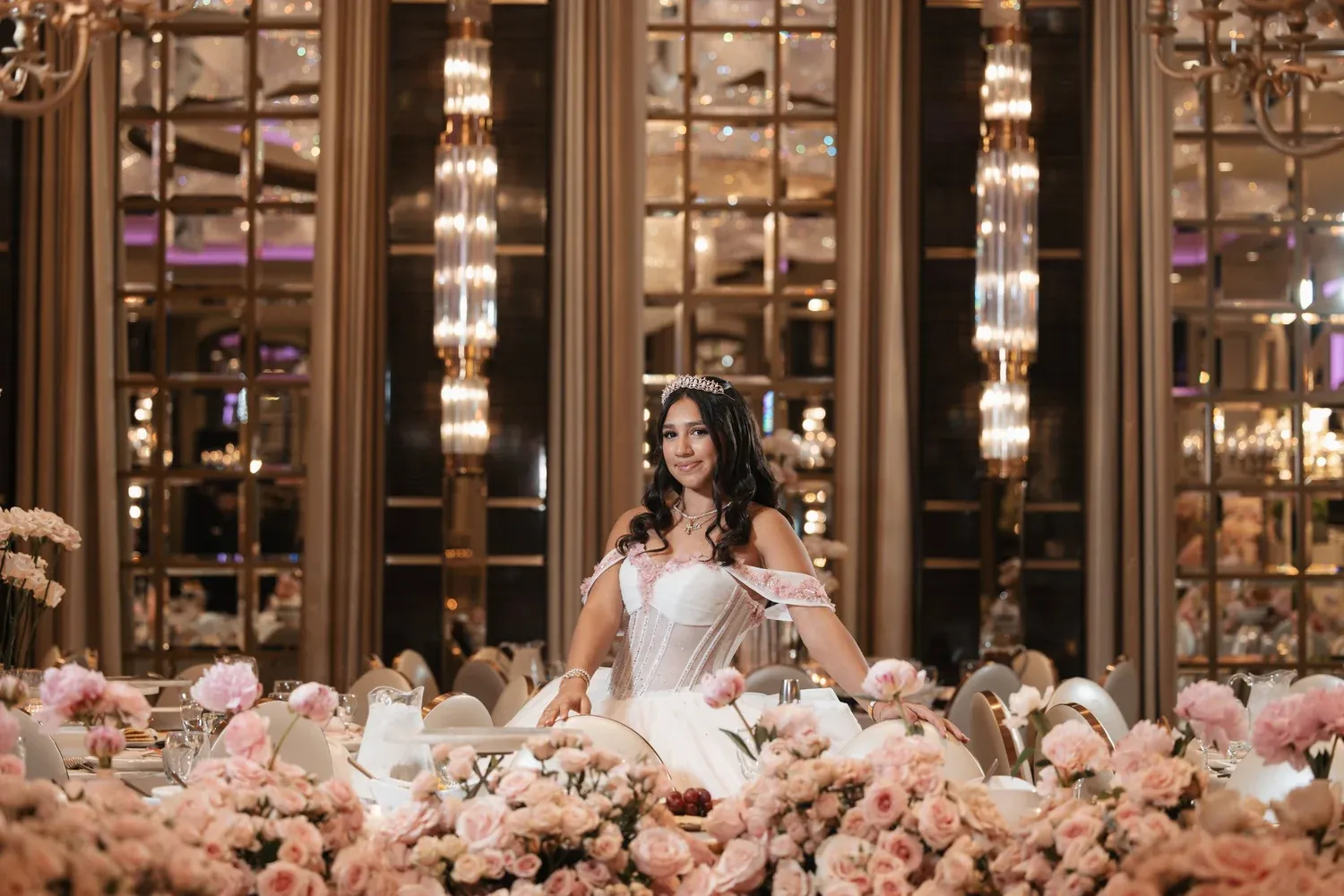 Quinceañera seated behind pink and cream roses at Grand Venue Los Feliz