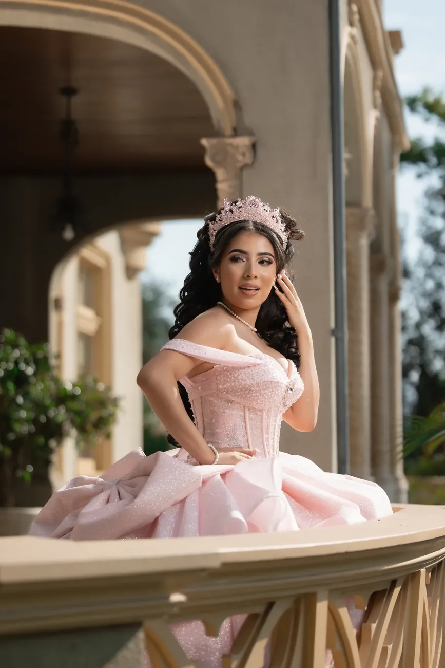 Quinceañera in a blush gown on a balcony terrace