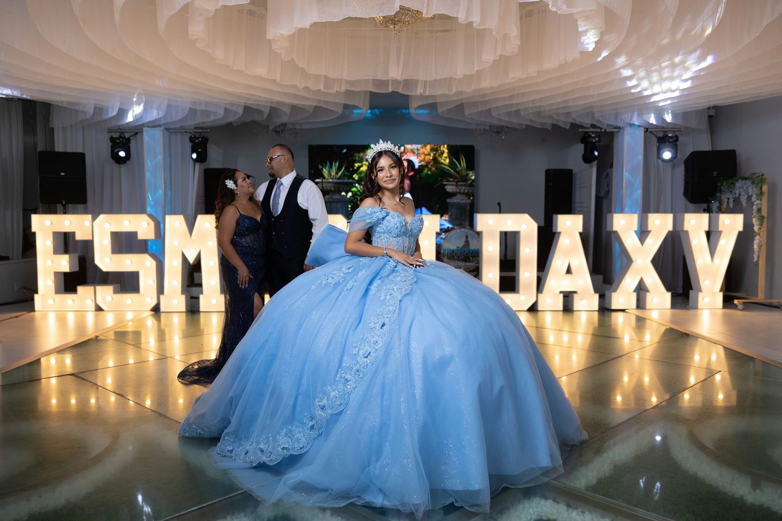 A sky-blue gown in front of marquee letters spelling her name