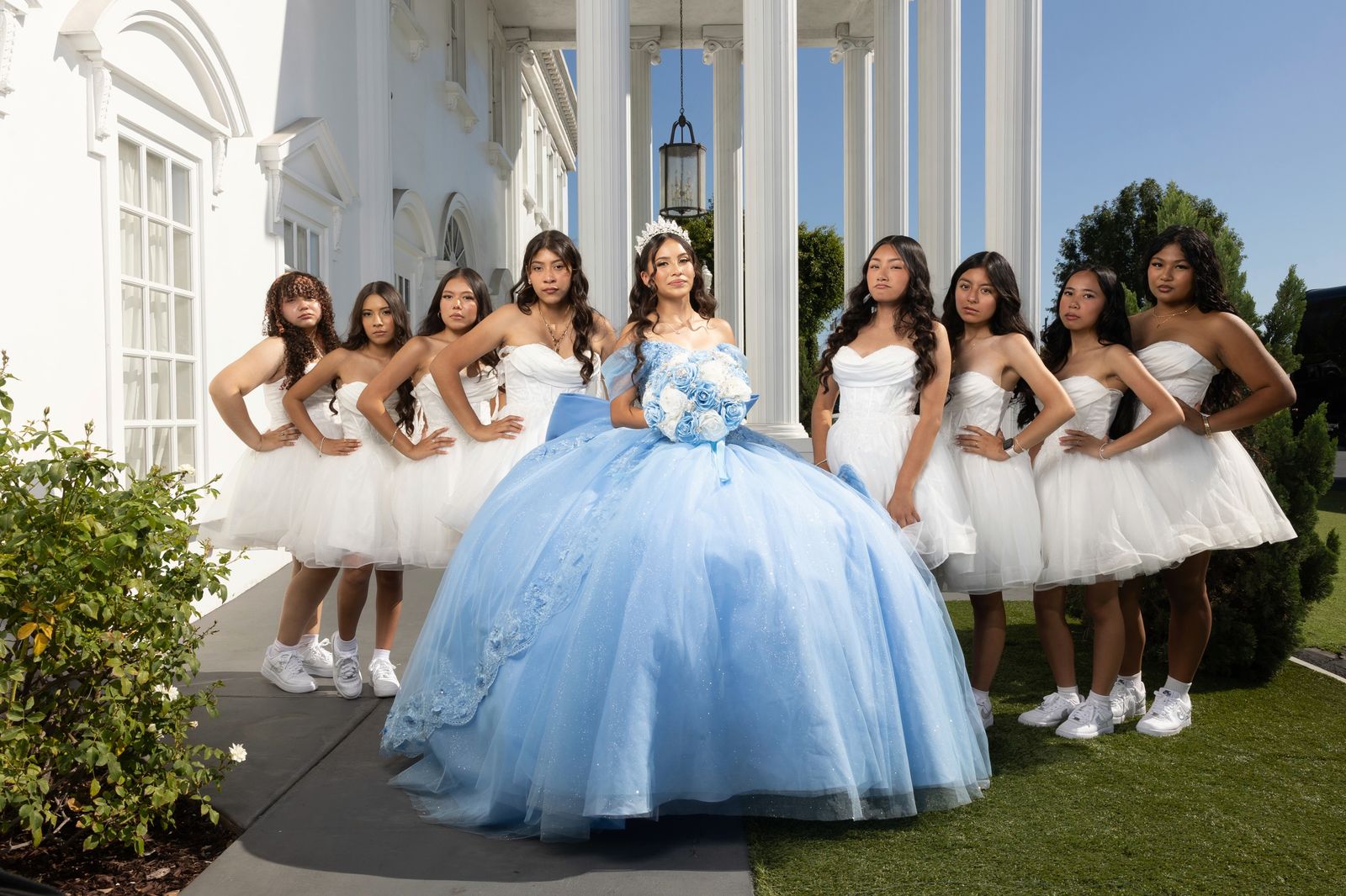 Damas in short white dresses around the quinceañera in sky blue